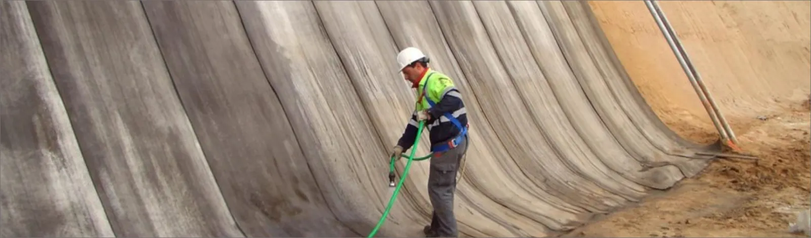 Técnico hidratando con manguera un talud revestido